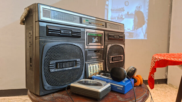 Vintage National Stereo Cassette Radio with Two Walkman Players on Wooden Table Retro Audio Equipment Collection
