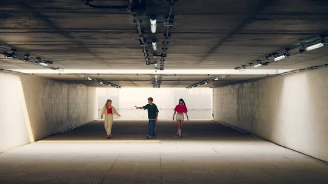 Asian people friends practicing longboard together in urban underpass enjoying outdoor active lifestyle improving skateboarding skills teamwork balance fitness and recreation extreme sport in the city