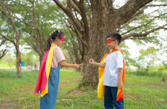 Children Playing Rock Paper Scissors in Superhero Costumes During Outdoor Pretend Play, Building Friendship, Teamwork, Decision Making, and Joyful Childhood.