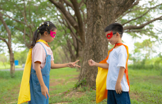 Children Playing Rock Paper Scissors in Superhero Costumes During Outdoor Pretend Play, Building Friendship, Teamwork, Decision Making, and Joyful Childhood