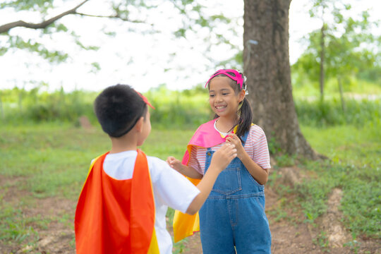 Smiling Children in Superhero Costumes Sharing a Friendly Moment During Outdoor Pretend Play, Encouraging Friendship, Communication, Teamwork, and Imaginative Childhood.
