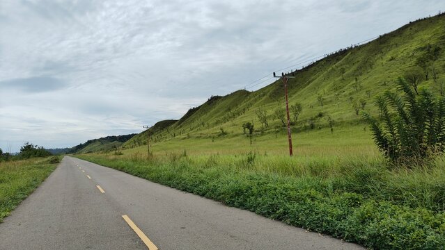 Scenic Mountain Road Surrounded by Lush Green Hills in Seram Island, Indonesia