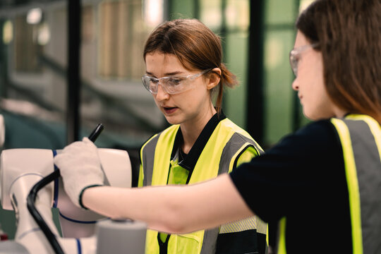 Female Engineer in Safety Vest Working on Advanced Industrial Component in Smart Factory. Precision Manufacturing and Female STEM Professional in High Tech Industry.