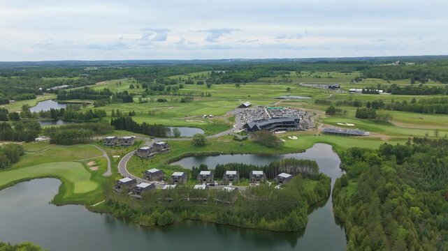 Sweeping drone video captures TPC Toronto Osprey Valley&rsquo;s scenic golf course, winding roads, modern clubhouse, tranquil water features, and verdant greenery under soft daylight.