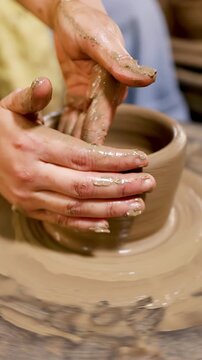 Artisan Hands Shaping Clay Pot on Traditional Spinning Pottery Wheel