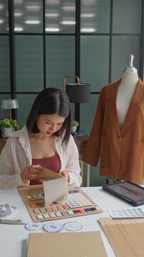 Asian woman designer using tablet design cloth