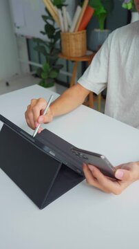 Asian businessman using tablet and holding smartphone