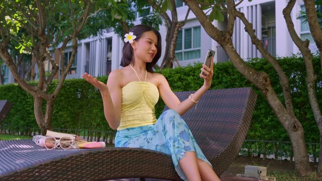 Asian woman in swimsuit taking sefie on smartphone