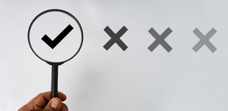 Hand holding a magnifying glass over a check mark beside rejected options representing correct selection
