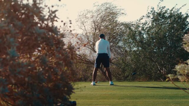 Scratch golfer hits driver in exterme slow motion, teebox framed by desert trees at golden hour, 4k 800fps slow motion