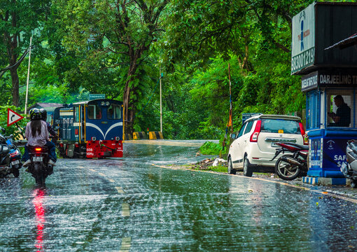 June 06,2026.Rongtong,Darjeeling, India, West Bengal. This scene captures the Darjeeling Himalayan Railway, a UNESCO World Heritage Site known as the "Toy Train". passing a highway in the monsoon seas