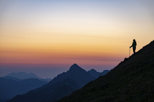 Mountaineer on mountain ridge with Rothorn peak in the background at blue hour, Interlaken, Bernese Oberland, Switzerland