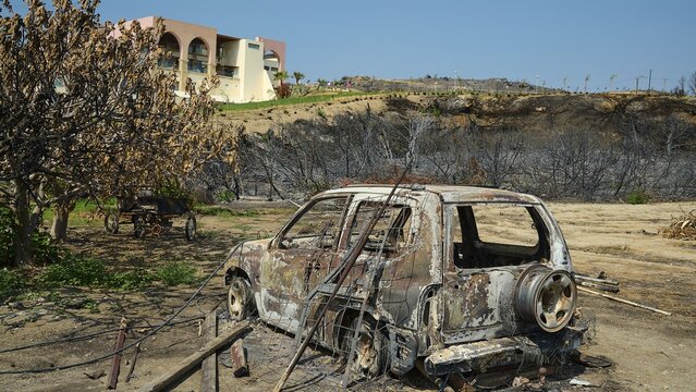 Burnt car in a landscape destroyed by a fire, buildings and dry trees in the background, forest fires, summer 2023, forest fire damage, Boutique 5 Hotel, Kiotari, Rhodes, Dodecanese, Greek Islands, Greece