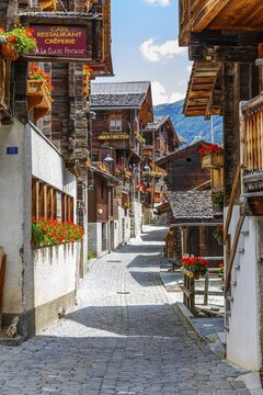 Paved footpath surrounded by old wooden houses, flower boxes on balconies and windows, historic village centre, Grimentz, Val d'Anniviers, Valais Alps, Canton Valais, Switzerland
