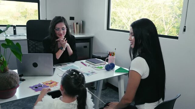 Child psychologist using flashcards in therapy session with mother