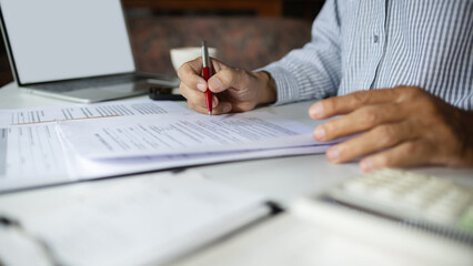 Fototapeta na wymiar close-up shot, businessman work on desk with laptop doing business document and review compay' accounting