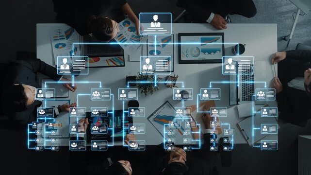 Aerial view of a busy office team collaborating on strategies with a digital organization chart showcasing the hierarchical structure and workflow among team members. Raster