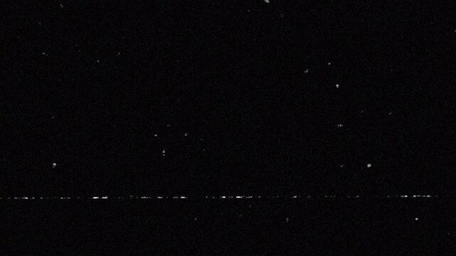 old film noise 8mm  footage texture with black grainy night sky, static noise pattern, bright white star dots. Suitable for spacethemed designs, backgrounds, digital art.