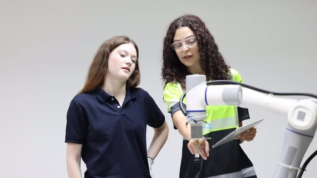 Female industrial engineer study inspection control robot arm machine in robotics engineering, Robotic learn operating, programming, troubleshooting quality control demonstrations of robotic arms. AI