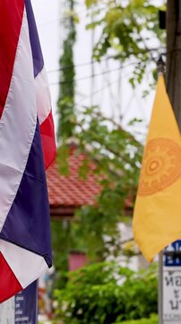 Thai National and Buddhist Flags Waving Outside a Traditional Temple