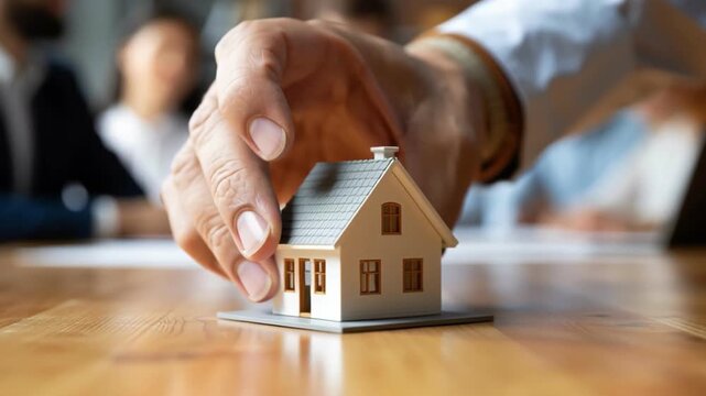 Miniature house model on wooden table with hand, real estate home property, sale and mortgage concept for SEO search URL title