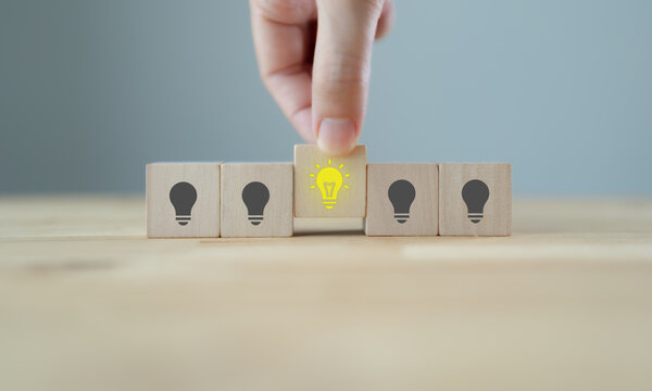 Customer Insight and Business Intelligence. Glowing light bulb block among wooden cubes, symbolizing customer insight, business intelligence, data-driven decisions, innovation and strategic thinking.
