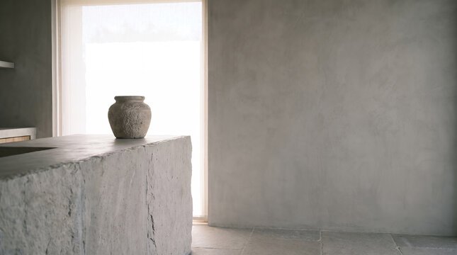 Rustic stone vase on a microcement counter beside a bright window