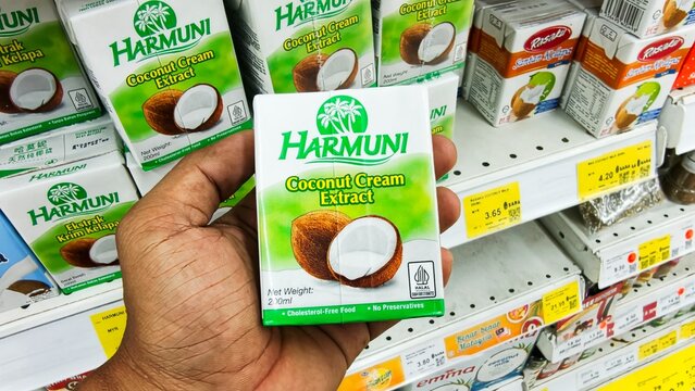 Malaysia Kuala Terengganu, 20 July 2026: Hand holding Harmuni brand coconut milk at the supermarket. coconut cream extract 200ml