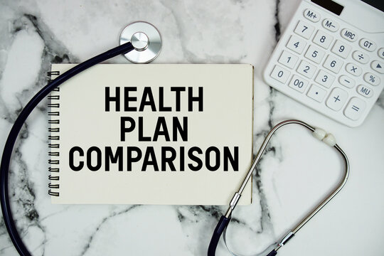 Health Plan Comparison text written on notepad with stethoscope and  calculator on marble background