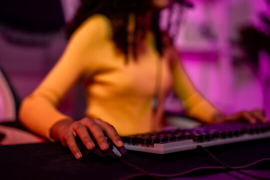 Close up of African American teenage girl playing online video game on computer. 