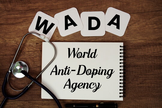 WADA World Anti-Doping Agency text written on notepad with stethoscope on wooden background