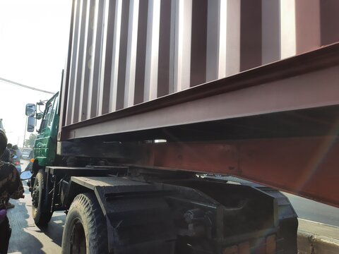 Low angle shot of shipping container box mounted on semi truck trailer chassis