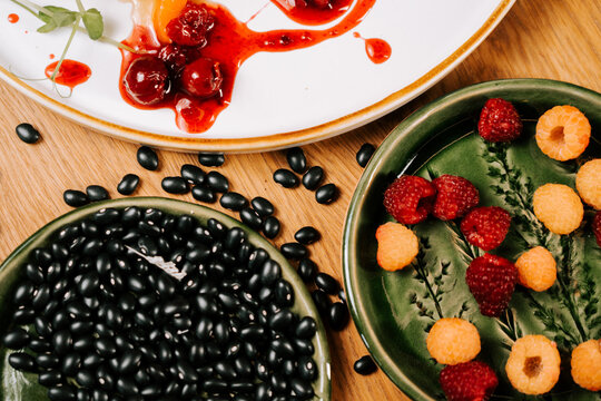 Black beans and fresh raspberries arranged on small decorative plates for a light meal