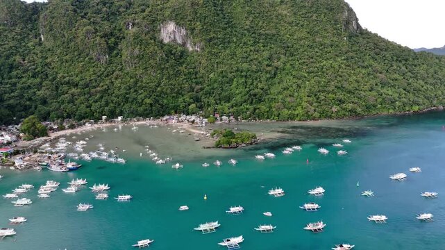 Aerial view of boats anchored in el nido palawan philippines, tropical island landscape in motion.