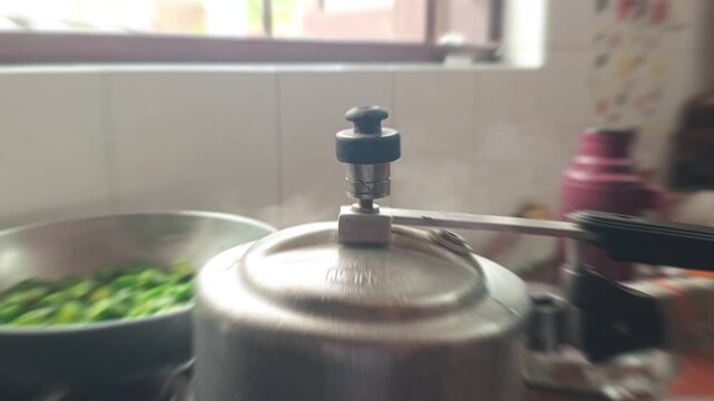 Close up of pressure cooker whistle releasing hot steam in kitchen