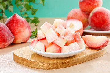 Fresh sliced flat peaches in bowl with whole peaches © TrinhVan