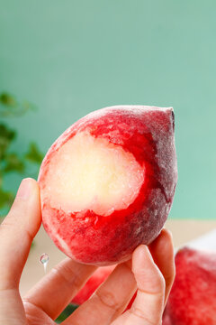 Hand Holding Bitten Juicy Red Peach Close Up