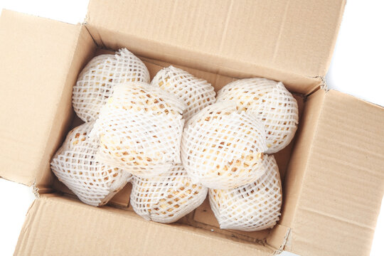 Fresh pears in foam net sleeves packed in open cardboard box