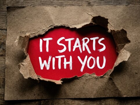 Torn paper reveals red background with white text "IT STARTS WITH YOU", promoting personal empowerment and responsibility Concept, encouraging action for self-improvement and motivation.