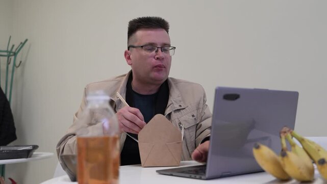 Man eating lunch using knife and fork, formal dining, meal time at office.