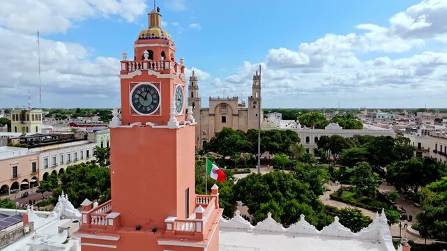 Aerial view of a tall red colonial building with a clock tower in central Merida, Yucatan, Mexico, rising above the historic city centre.