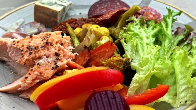 Colorful plate of assorted Nordic food with salmon, cheese, salad, and vegetables
