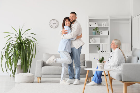 Happy young couple hugging after IVF at fertility doctors office