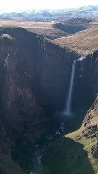 Maletsunyane falls in lesotho africa cinematic drone shot of huge waterfall in high rocky canyon cliff.