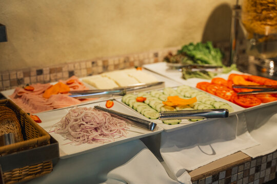Hotel breakfast buffet offering fresh vegetables, cold cuts and cheese