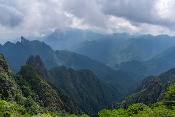 A panoramic view of the majestic green peaks and forested mountains at Sanqingshan Mountain in Jiangxi province of China under a cloudy sky © AS_SleepingPanda