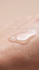 Fototapeta premium Clear cosmetic serum droplet on human skin