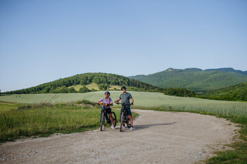 Obraz premium Active senior couple exploring nature on electric bicycles