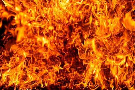 Flame burns beside bright flames. Flame glows above orange flames. Realistic flame with fire. Burning flame beside fire.