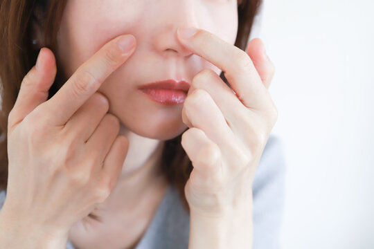 小鼻の毛穴をチェックする女性